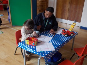 A child practicing her writing with a teacher.