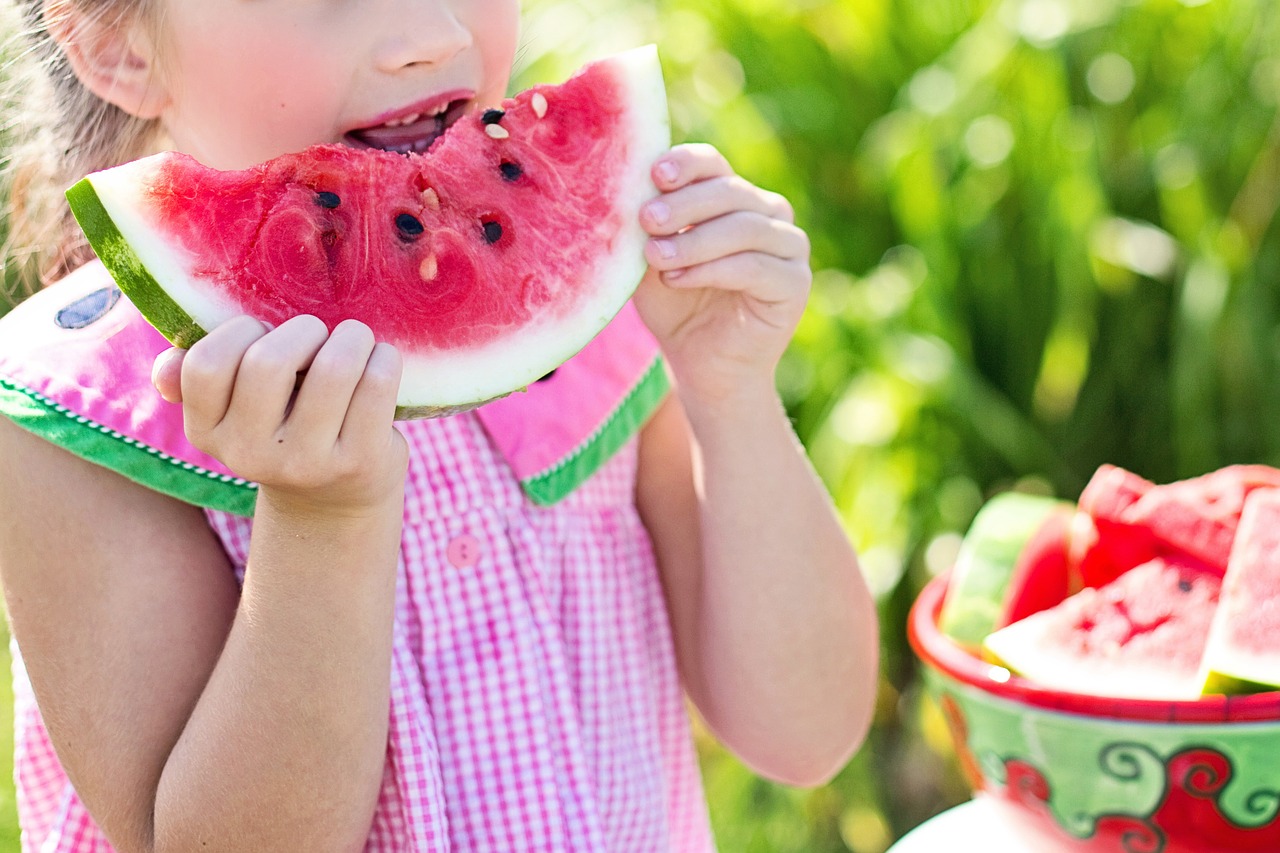 A girl eating a slice of watermelon